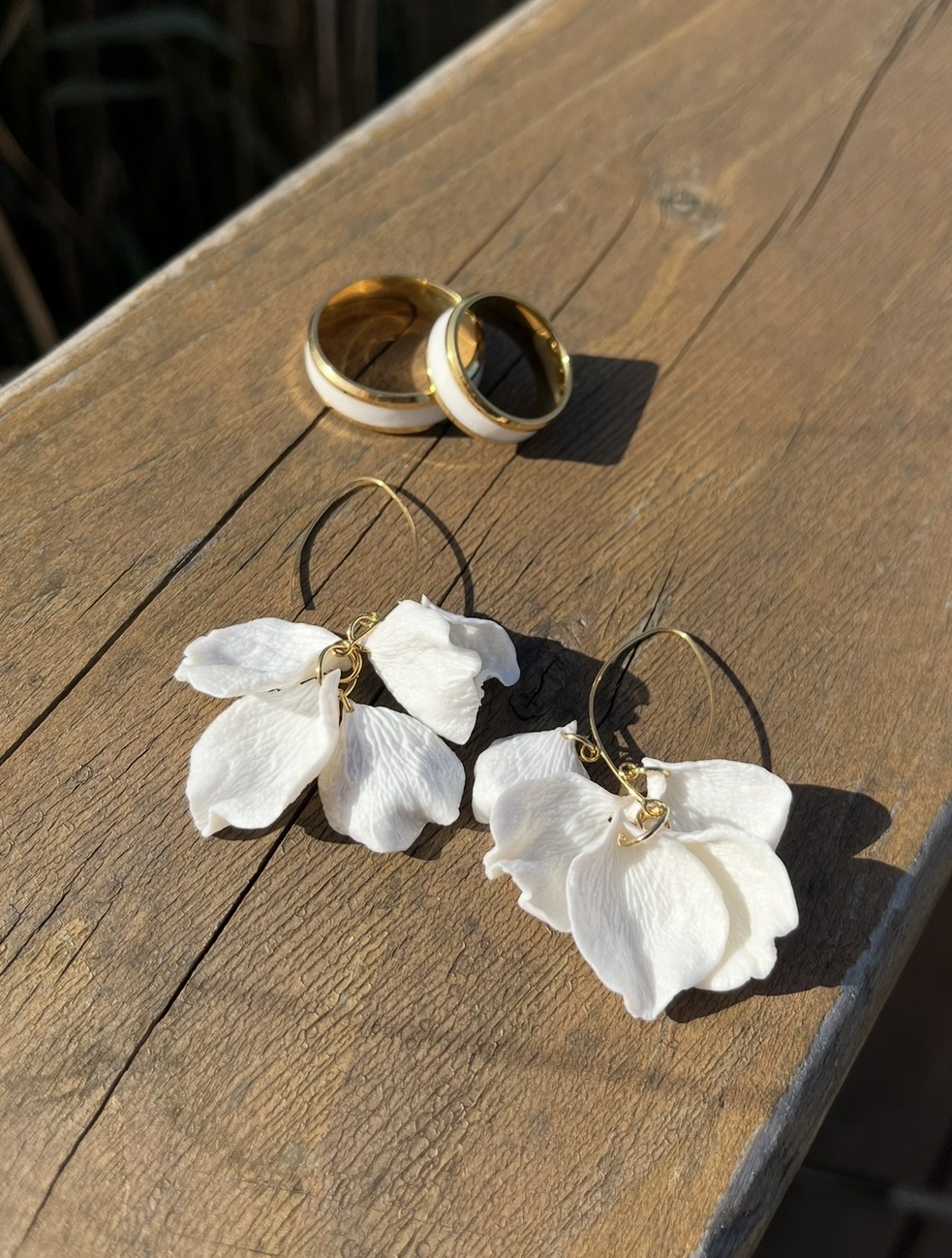 White hand-shaped petal earrings in warm sunlight