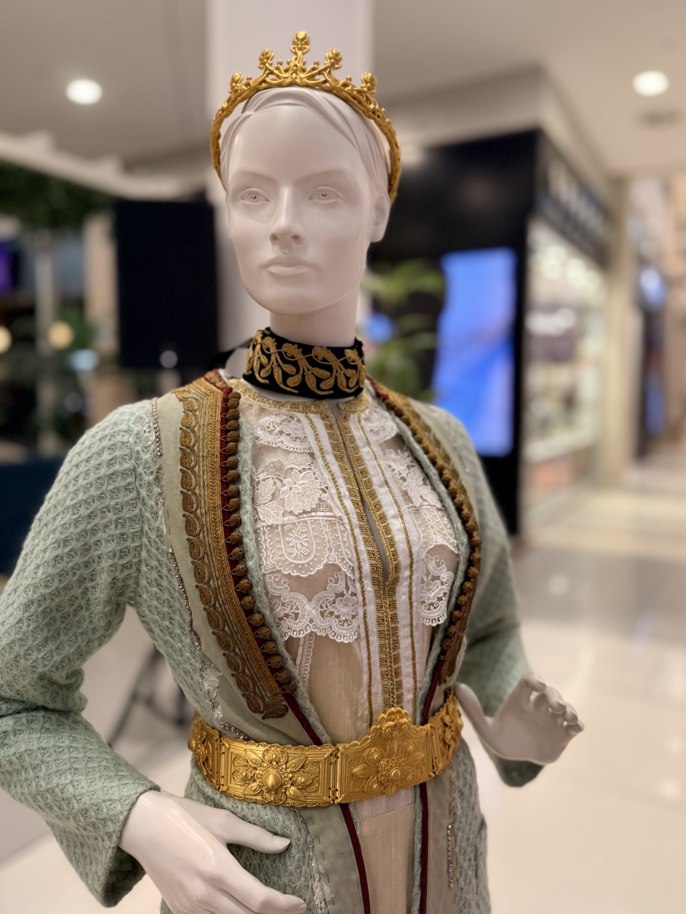 Svijetlozelena istorijska haljina inspirisana Jelenom Savojskom, izložena sa krunom i ukrasnim detaljima
