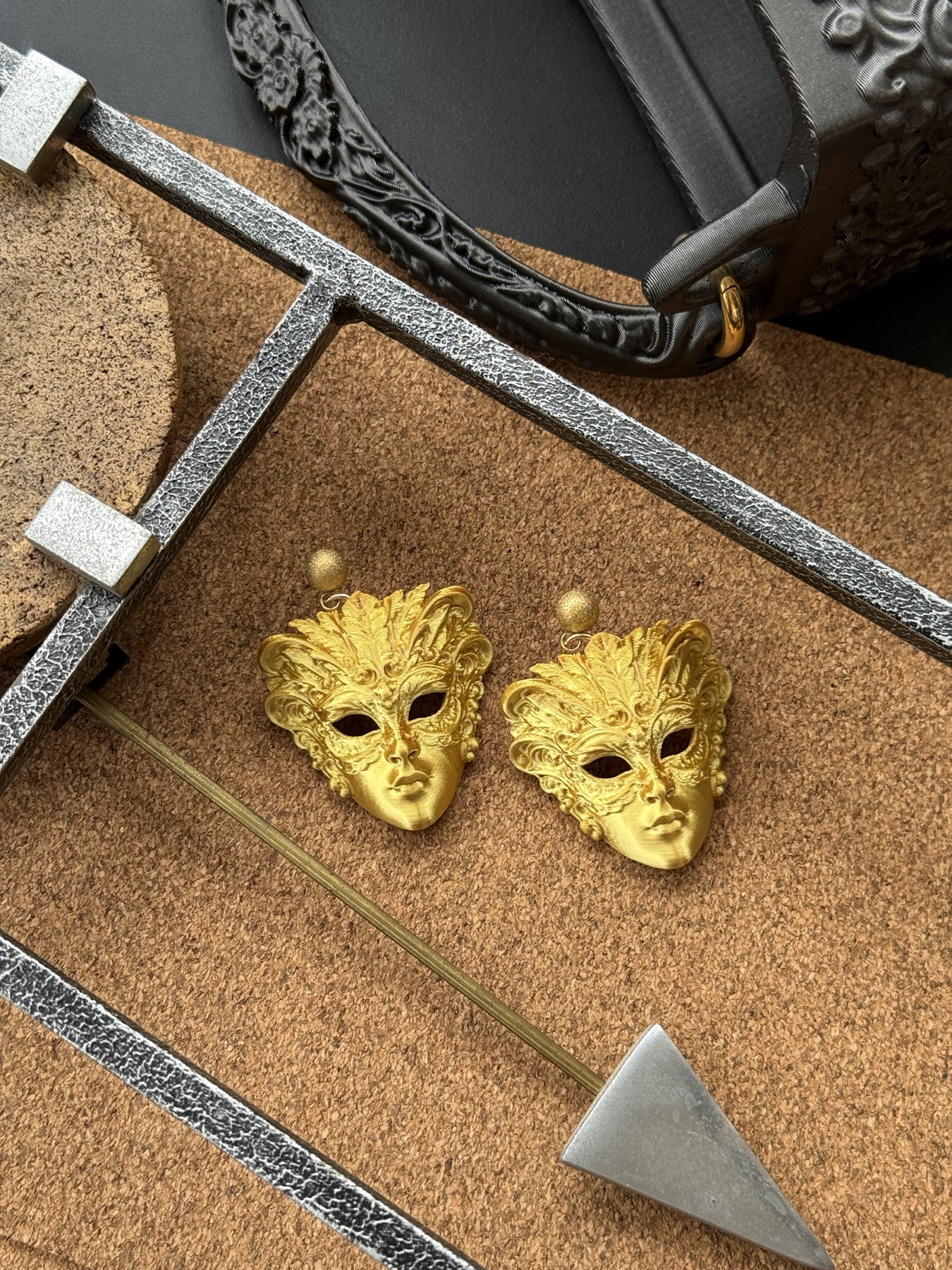 Gold carnival mask jewellery arranged with sculptural objects